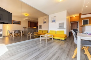 Un salon moderne avec un canapé, une table basse et un coin repas.