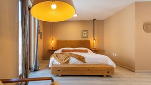 A bedroom with a wooden bed, two bedside tables, a hanging lamp, and a view of the hallway. - CASA H (San Miguel de Allende)