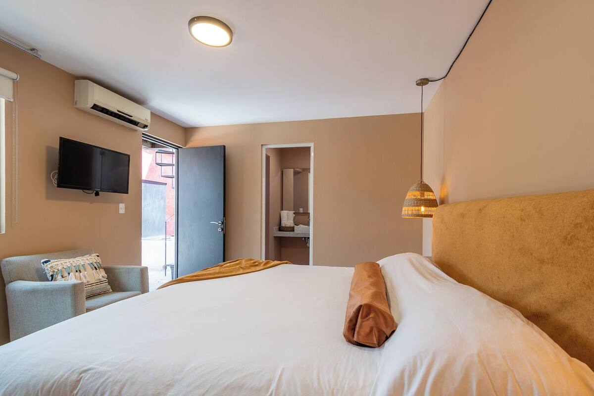 Une chambre avec un lit, une télévision, un appareil de climatisation et une armoire.
