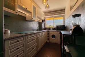 A compact kitchen with a washing machine, a microwave, and a toaster. - Cosy apartment with Balcony near the Beach (Biarritz)