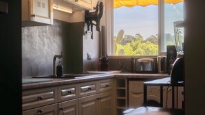 A kitchen with a window, a toaster, a kettle, and a coffee maker. - Cosy apartment with Balcony near the Beach (Biarritz)