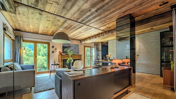 A modern kitchen with a central island, wooden ceiling, and large windows. - Rochebrune (Megève)