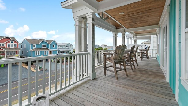 A covered porch with a view of houses, wooden deck, and a railing. - "2ice As Nice" - 4 Bedrooms, 3.5 Bathrooms, Private Pool (Holden Beach)