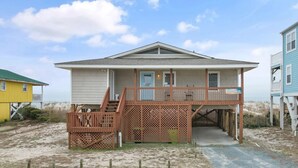 A beach house with a covered porch, a staircase, and a small deck. - "Charisma"  4 Bedroom, 2 Bathroom, Oceanfront (Holden Beach)