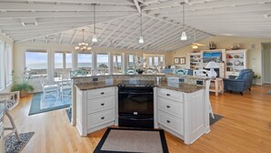 A spacious kitchen with a high ceiling, large windows, and a view of the ocean. - "Goins My Way" 6 Bedrooms, 6.5 Bathrooms, Private Pool and Elevator (Holden Beach)