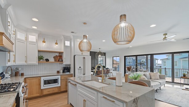 A modern kitchen with white cabinetry, a marble island, and pendant lighting. - 5 Bedrooms, 5 Bathrooms, Private Pool (Holden Beach)