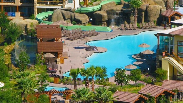 A resort with a large pool, a water slide, and multiple buildings with balconies. - Resorts among beautiful mountains in Escondido, CA with 2 beds,full kitchen (Escondido)
