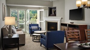 A living room with a sofa, armchair, coffee table, fireplace, television, and a dining table with chairs. - Resorts among beautiful mountains in Escondido, CA with 2 beds,full kitchen (Escondido)