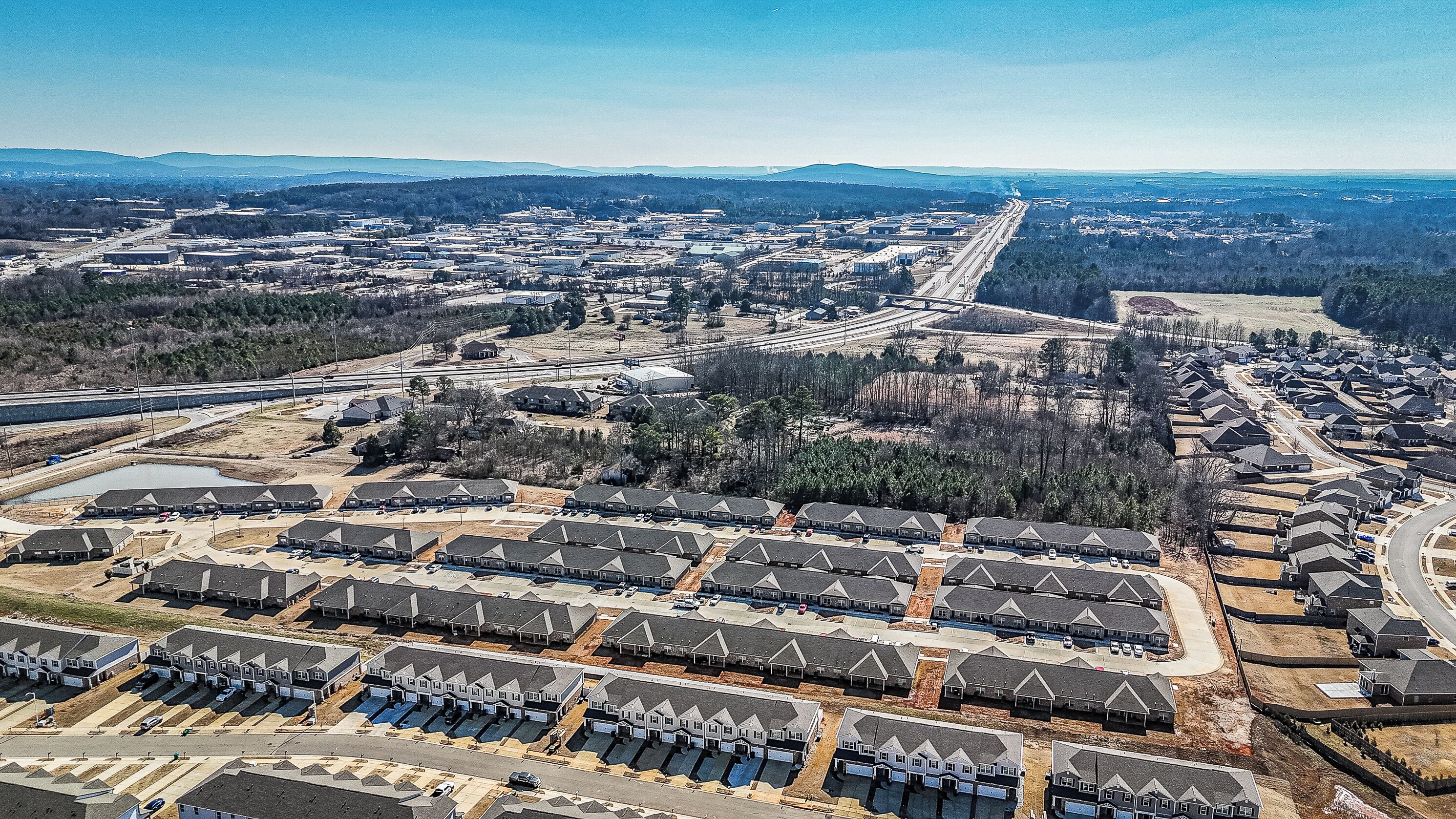Vista aérea de una zona residencial con varias viviendas, calles y una autopista.