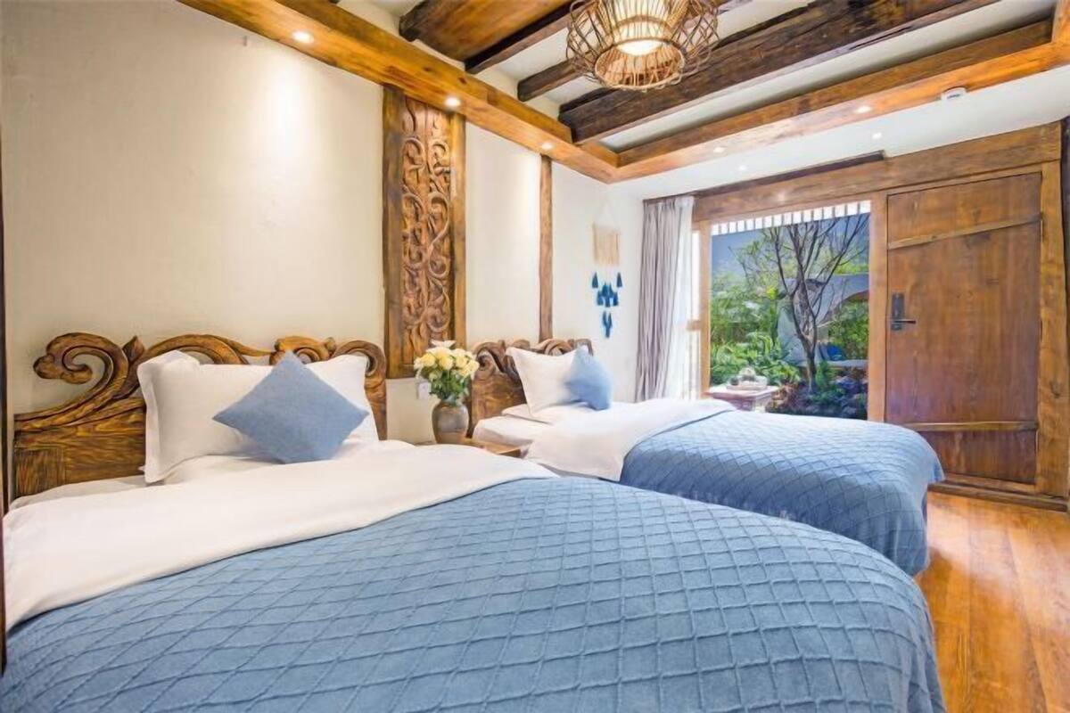 A bedroom with two beds, wooden headboards, and a large wooden wardrobe.