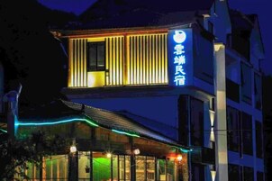 Un hotel con una fachada moderna, señalización iluminada y una entrada visible con puertas de vidrio.