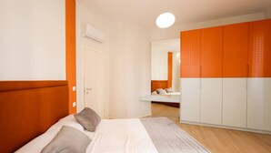 Quarto com cama, guarda-roupa e espelho.