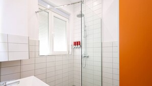 A bathroom with a shower, a sink, and a window. - Heart of Durres Apartment 02 (Durrës)