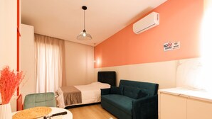 A compact hotel room with a bed, a sofa, a dining table, and a kitchenette. - Heart of Durres Apartment 02 (Durrës)