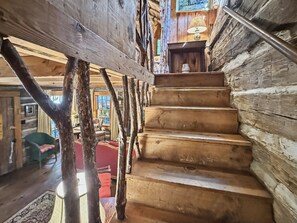 Eine Holztreppe in der Holzhaus-Innenausstattung mit Blick auf den Wohnbereich.