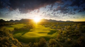 Un campo de golf con vistas despejadas a las montañas al fondo.
