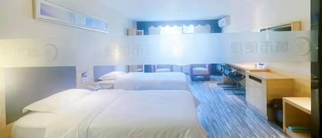 A hotel room with two beds, a desk, a chair, a TV, and a window.