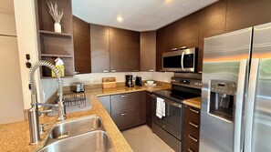 A modern kitchen with stainless steel appliances, a built-in oven, and a microwave.