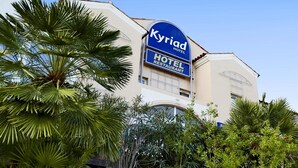 Een hotel met een opvallend bord waarop 'Kyriad Hotel Restaurant' staat en het nummer '422'.