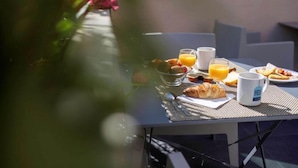 Een tafel met ontbijtproducten, zoals croissants, fruit en sinaasappelsap.