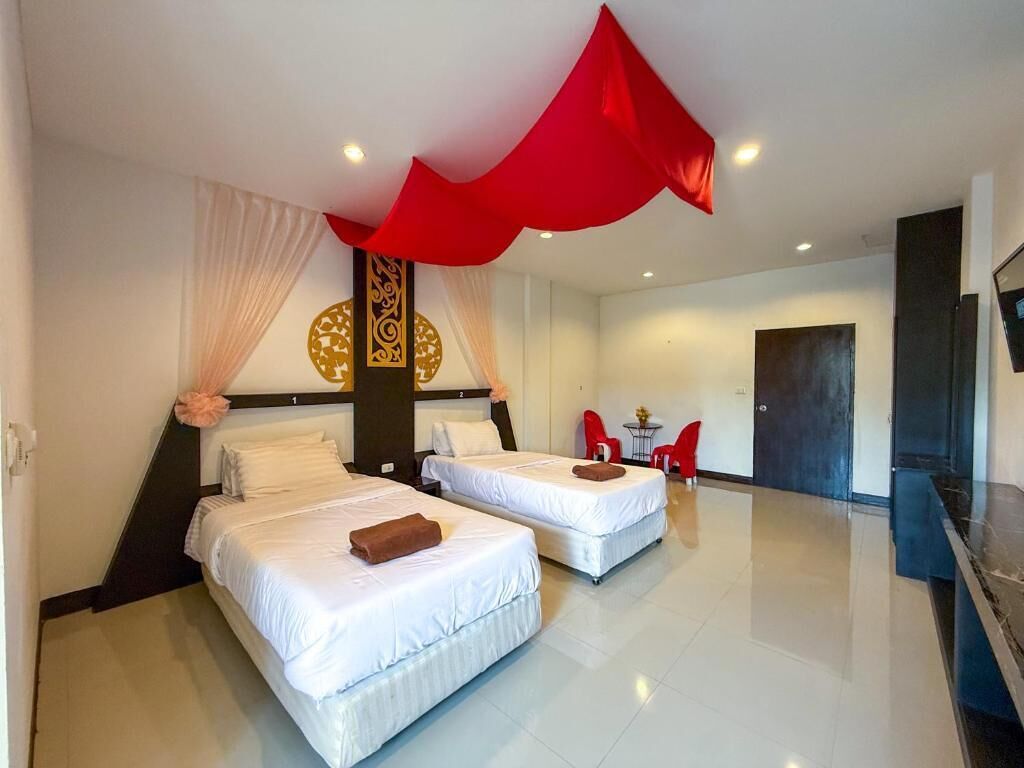 A hotel room with two beds, a dining area, and a staircase.