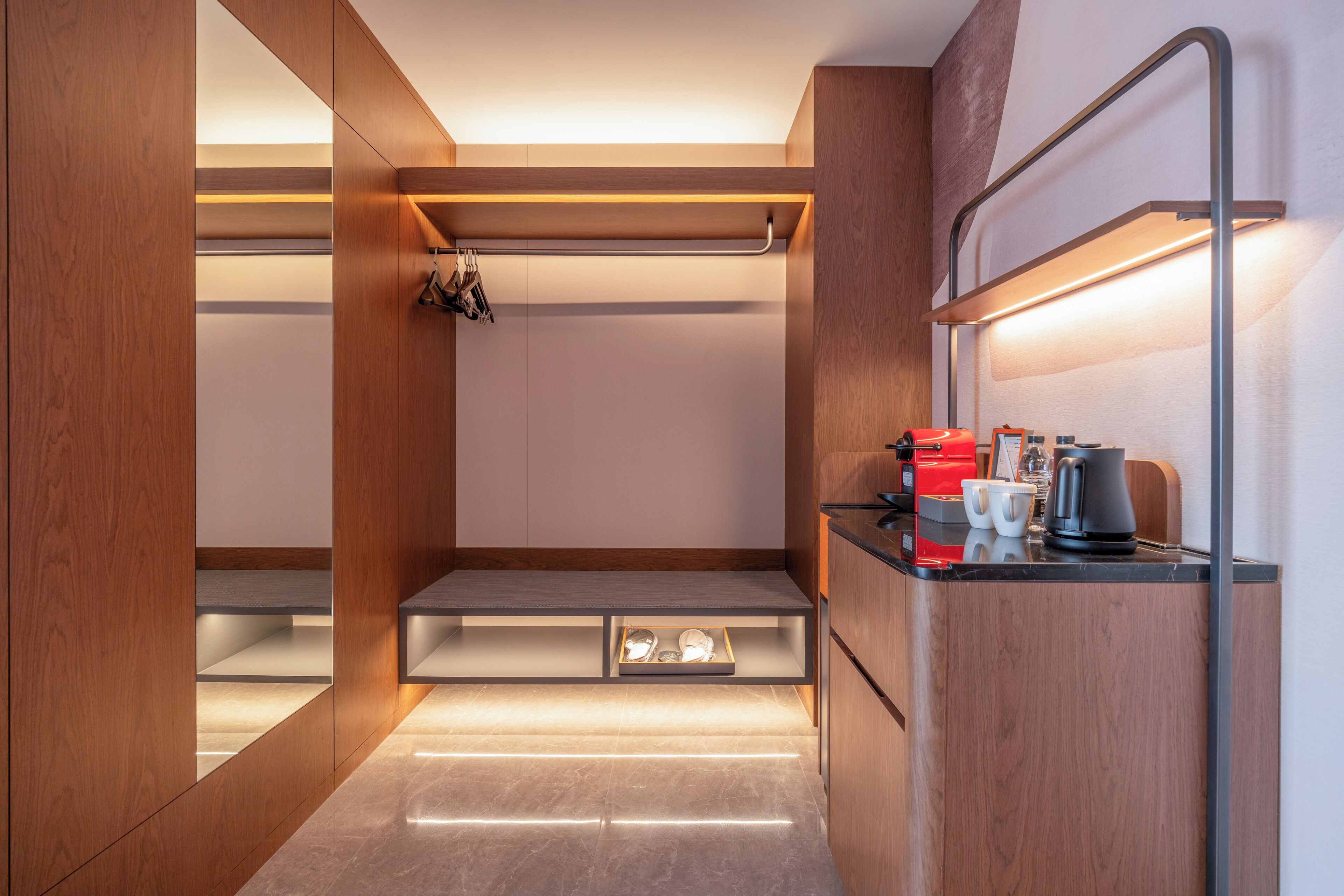 Une cuisine moderne dotée d’appareils électroménagers intégrés, d’un plan de travail et d’une étagère suspendue.