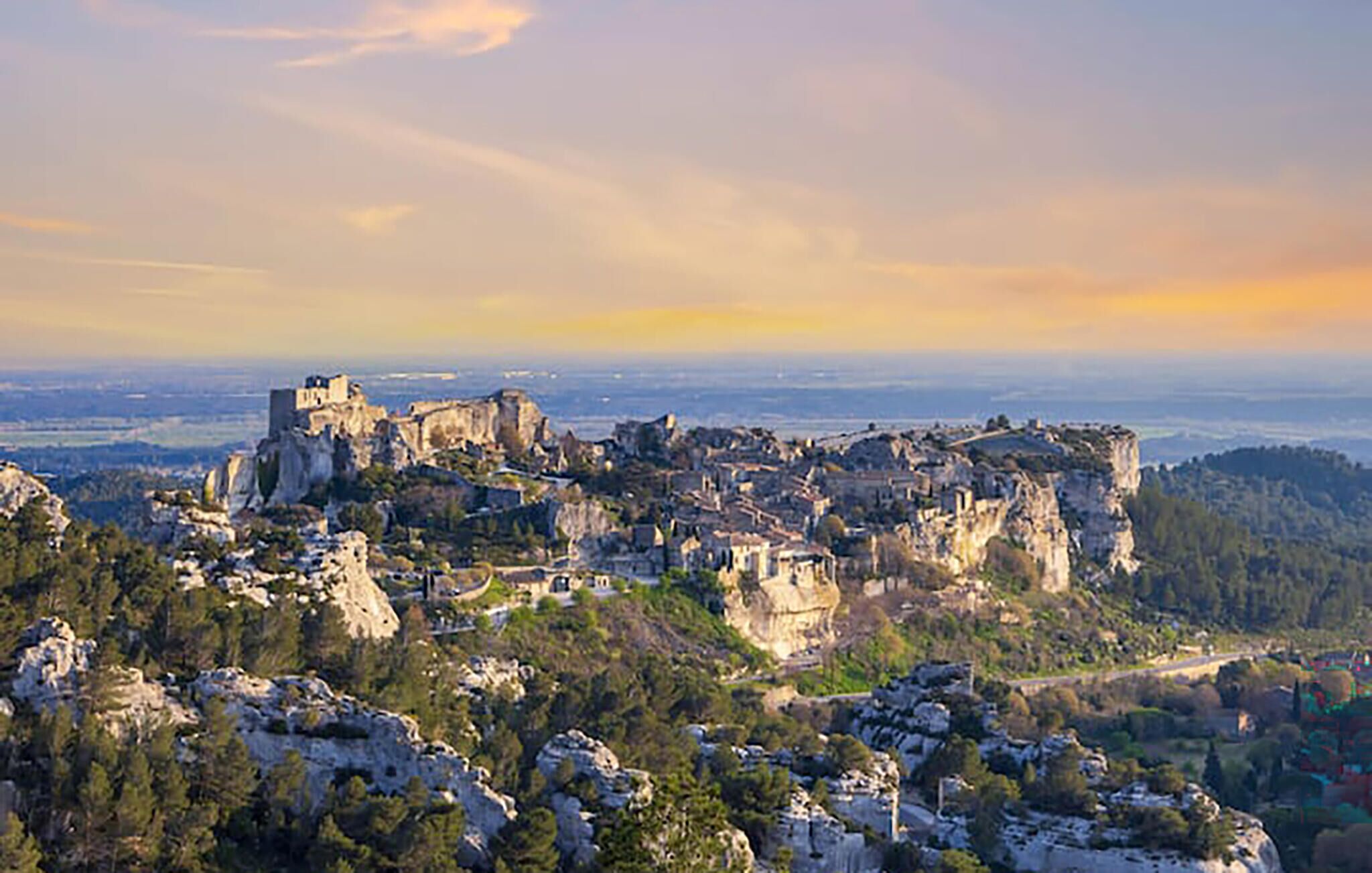 A panoramic view of a historic town built on rocky cliffs with a panoramic view of the surrounding landscape.