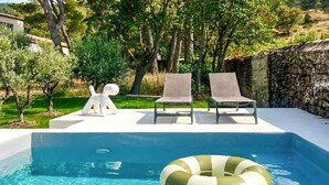 Une piscine avec des chaises longues et une bouée de sauvetage.