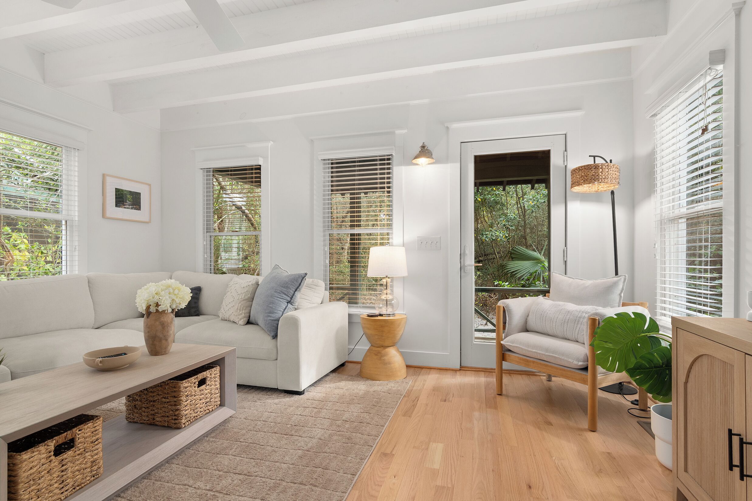 A modern living room with a sofa, armchair, coffee table, and side table.