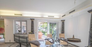 A spacious room with a marble floor, a large window, and a view of a garden. - FeWo GRANAT by Interhome (Wertach)