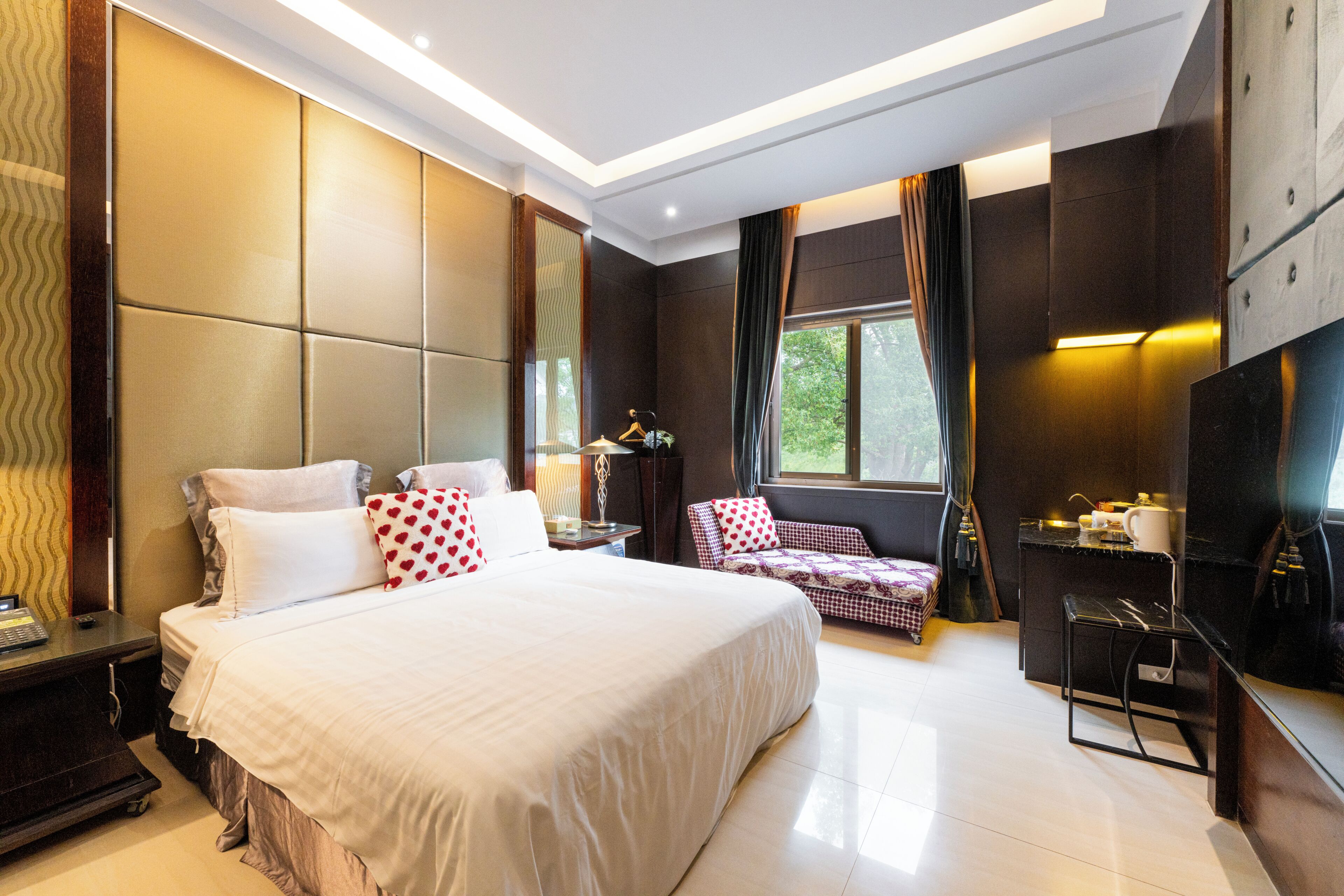 Une chambre d’hôtel moderne équipée d’un grand lit, d’un bureau, d’une chaise et d’une télévision.
