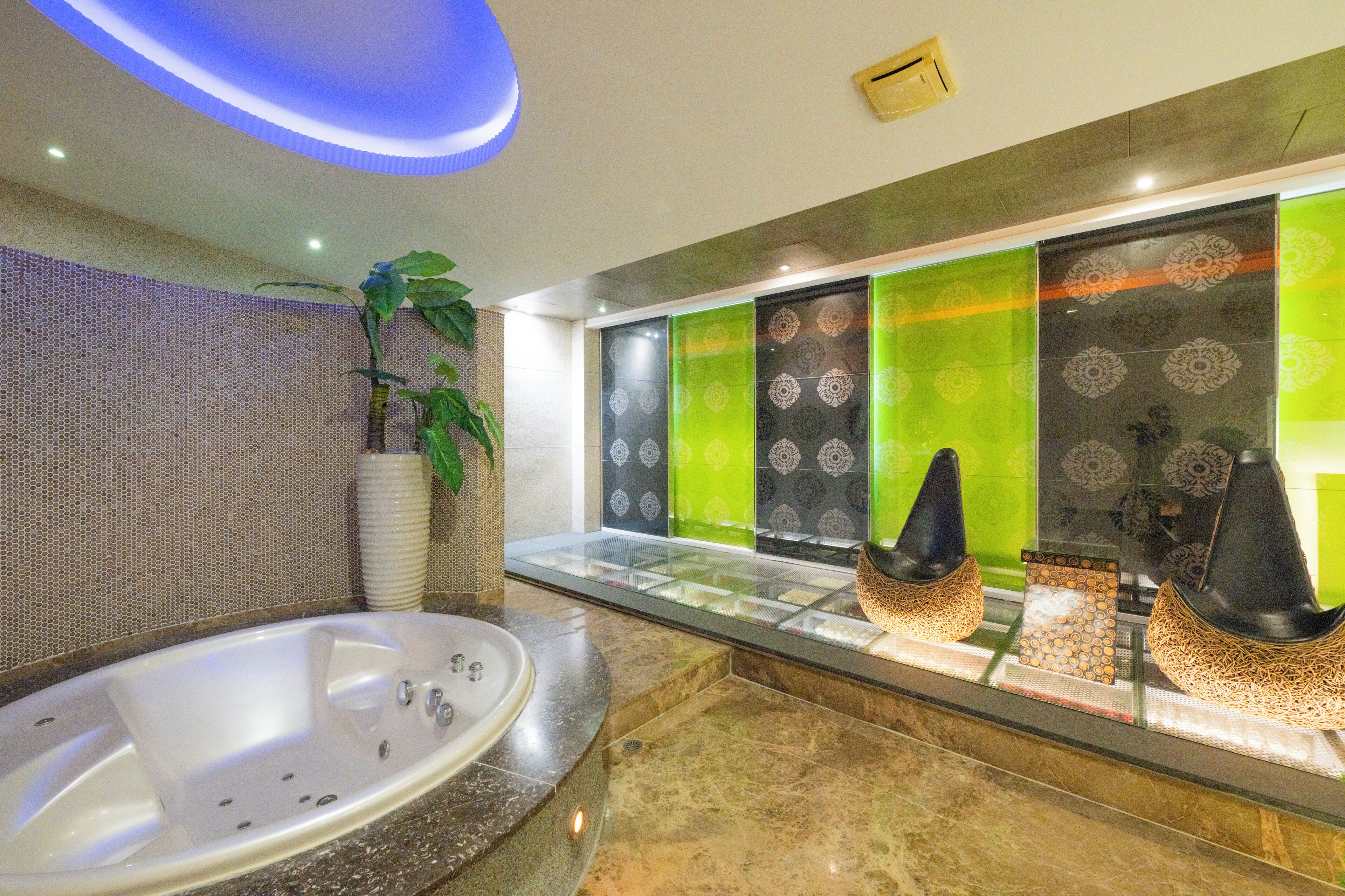 A modern bathroom with a large bathtub, a glass partition, and decorative wall panels.
