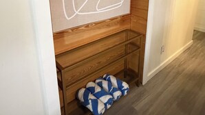 Ein Zimmer mit einer Holzeinbau-Bank, einer weißen Wand und einem hellen Boden.