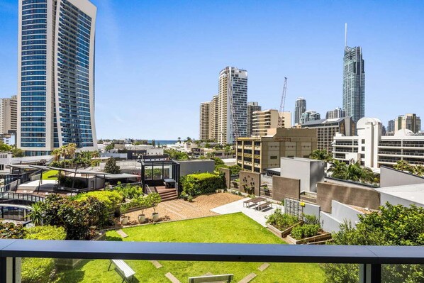 Un edificio alto con un giardino sul tetto e vista sullo skyline della città.