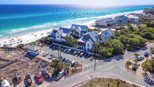 Un hôtel situé sur la côte, composé de plusieurs bâtiments, doté d’un parking et offrant une vue sur la plage.