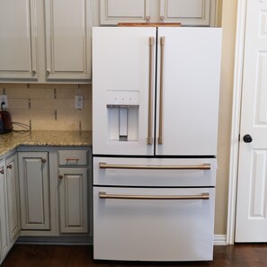 A kitchen with white cabinets, a double-door refrigerator, and a built-in water dispenser. - The Glam House 10mi from AT&T Stadium (Grapevine)
