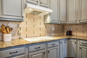 A kitchen with granite countertops, white cabinetry, and a toaster. - The Glam House 10mi from AT&T Stadium (Grapevine)
