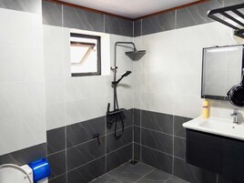 Un baño con ducha, lavamanos e inodoro.