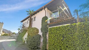 A two-story house with a balcony, a staircase, and a well-maintained garden. - Casa Viola Losone for 8, Losone, Switzerland (Losone)