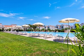 A pool area with lounge chairs and umbrellas, surrounded by buildings with red roofs. - Beach in 5 min | Pool Access | n.61, Otranto, Italy (Otranto)