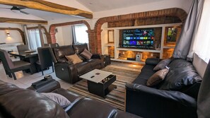 A living room with a fireplace, leather sofas, a coffee table, and a TV. - MADERO A" HOUSE. ZONA ROMANTICA PV. A SPACIOUS, COZY, CENTRALLY LOCATED APARTMENT (Puerto Vallarta)