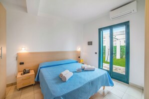 A hotel room with a bed, bedside table, nightstand, and an air conditioning unit. - Beach in 5 min | Pool Access | n.53, Otranto, Italy (Otranto)