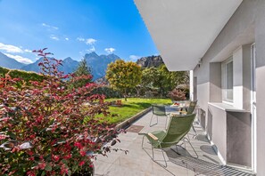 A patio with outdoor furniture, a view of mountains, and a well-maintained garden. - Villa Al Fiume - Oasi Verde in Torbole sul Garda, Torbole sul Garda, Italy (Torbole sul Garda)