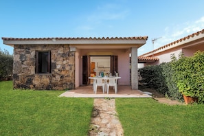 A stone house with a covered patio, a stone pathway, and a well-maintained lawn. - Le Case della Cinta 1 a 300 mt dal mare, San Teodoro, Italy (San Teodoro)