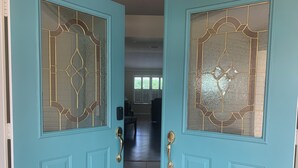 A teal double door with glass panels and a keypad lock. - Welcome to Coastal Retreat 
at Palo Alto! (The Villages)