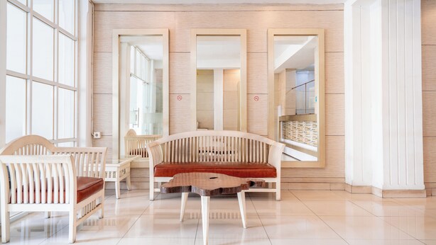 Un interno moderno con angolo salotto, ampie finestre e parete in legno.