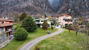 A residential area with houses, a winding road, and a mountainous backdrop.