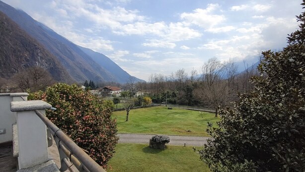 A mountainous landscape with a grassy area and a stone structure.