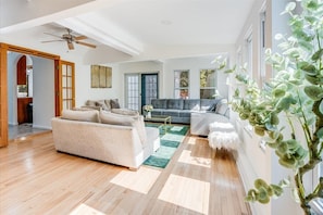 A spacious living room with a sofa, a grey couch, and a coffee table.