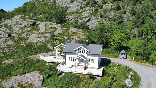 A white house with a balcony, surrounded by greenery and rocks. - Amazing home in Sømna with WiFi (Sømna)